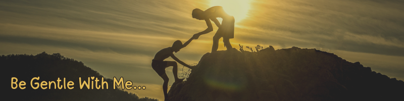 hiker helping another hiker climb a hill