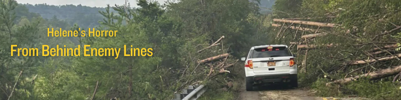 A car inches past downed trees in west North Carolina