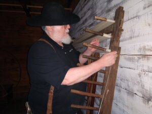 A man threading a warping board.