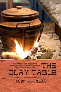 Cover of The Clay Table, showing a clay pot over hot coals.