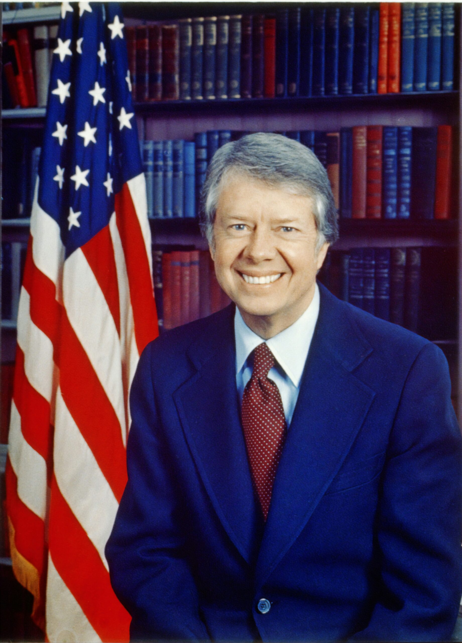 [Jimmy Carter, head-and-shoulders portrait, facing front, next to an American flag]. Photograph by photographer Karl Schumacher, 1977. From the Presidential File Collection. Library of Congress Prints & Photographs Division. https://www.loc.gov/item/96522672/