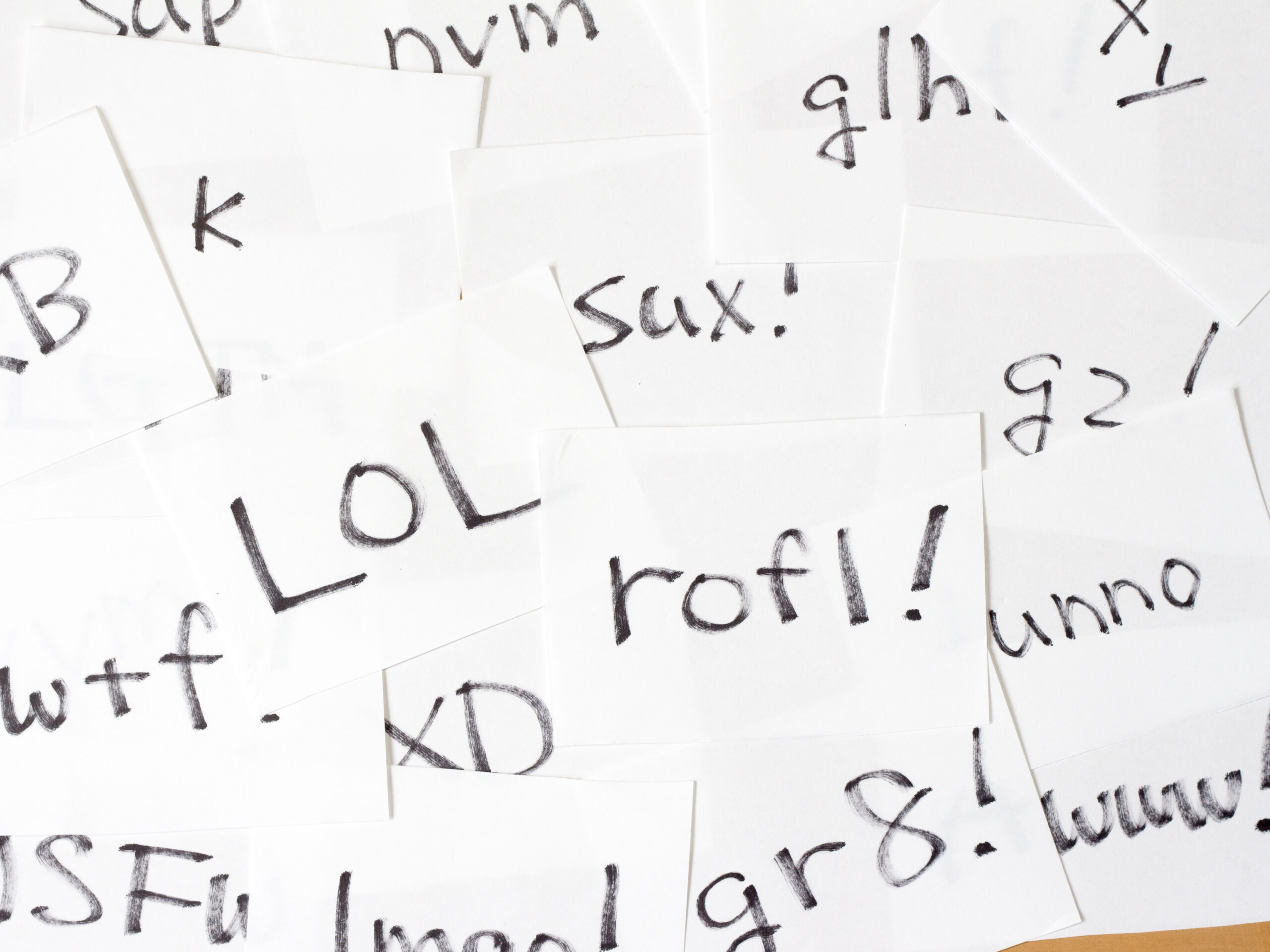 Hodgepodge of handwritten Eglish internet slang cards, high angle