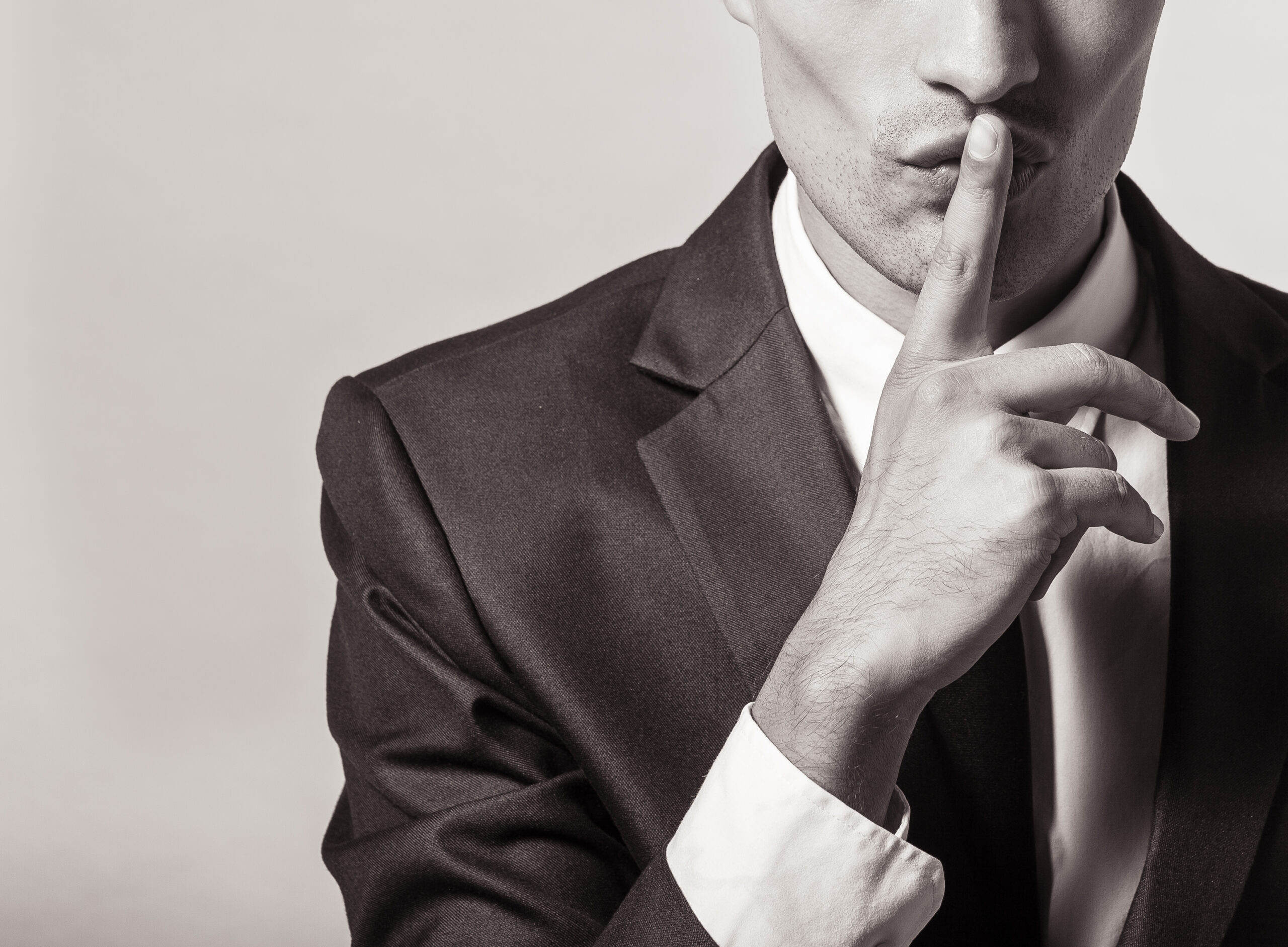 Portrait of a young businessman with finger on his lips