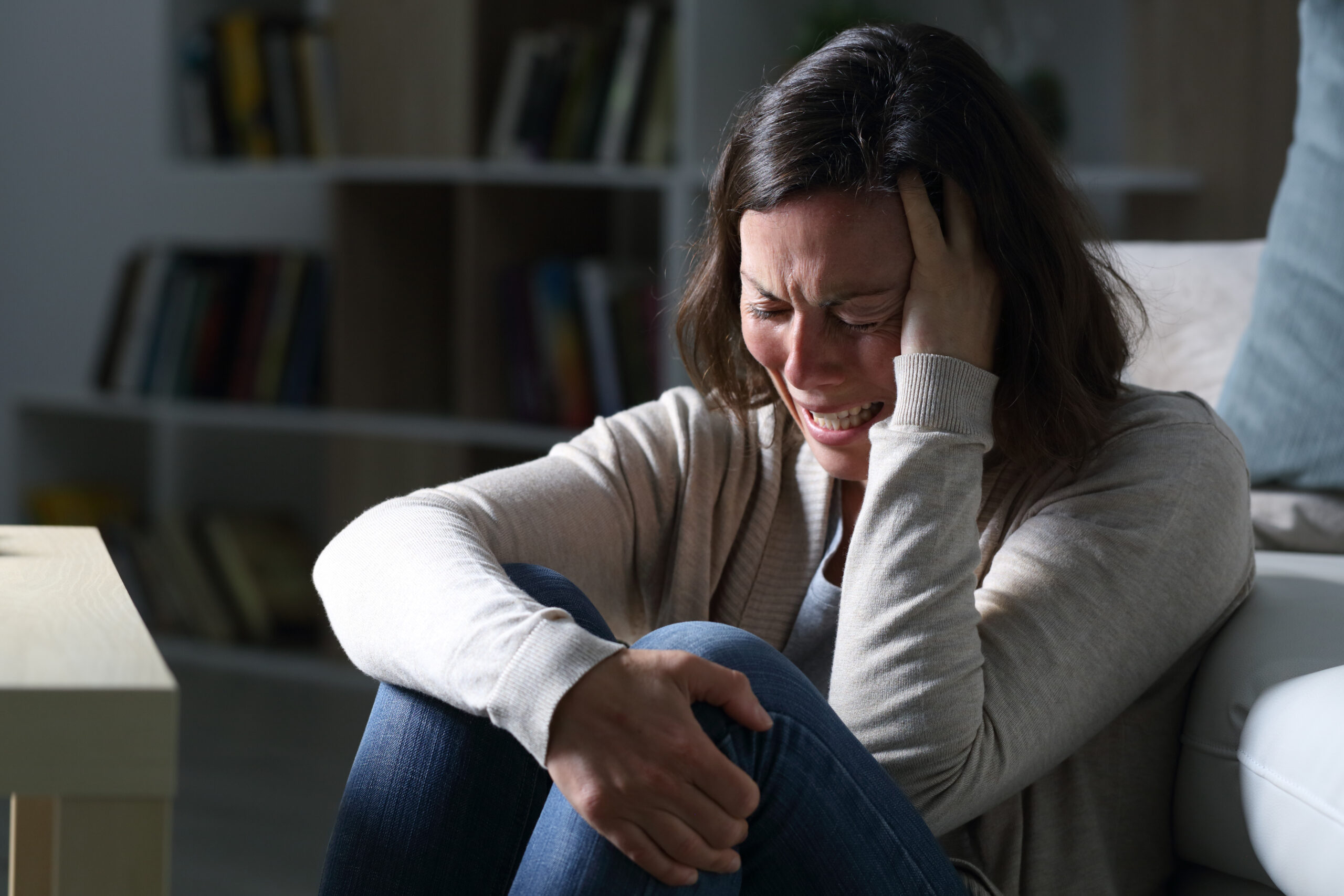 Sad middle age woman crying sitting in the night at home