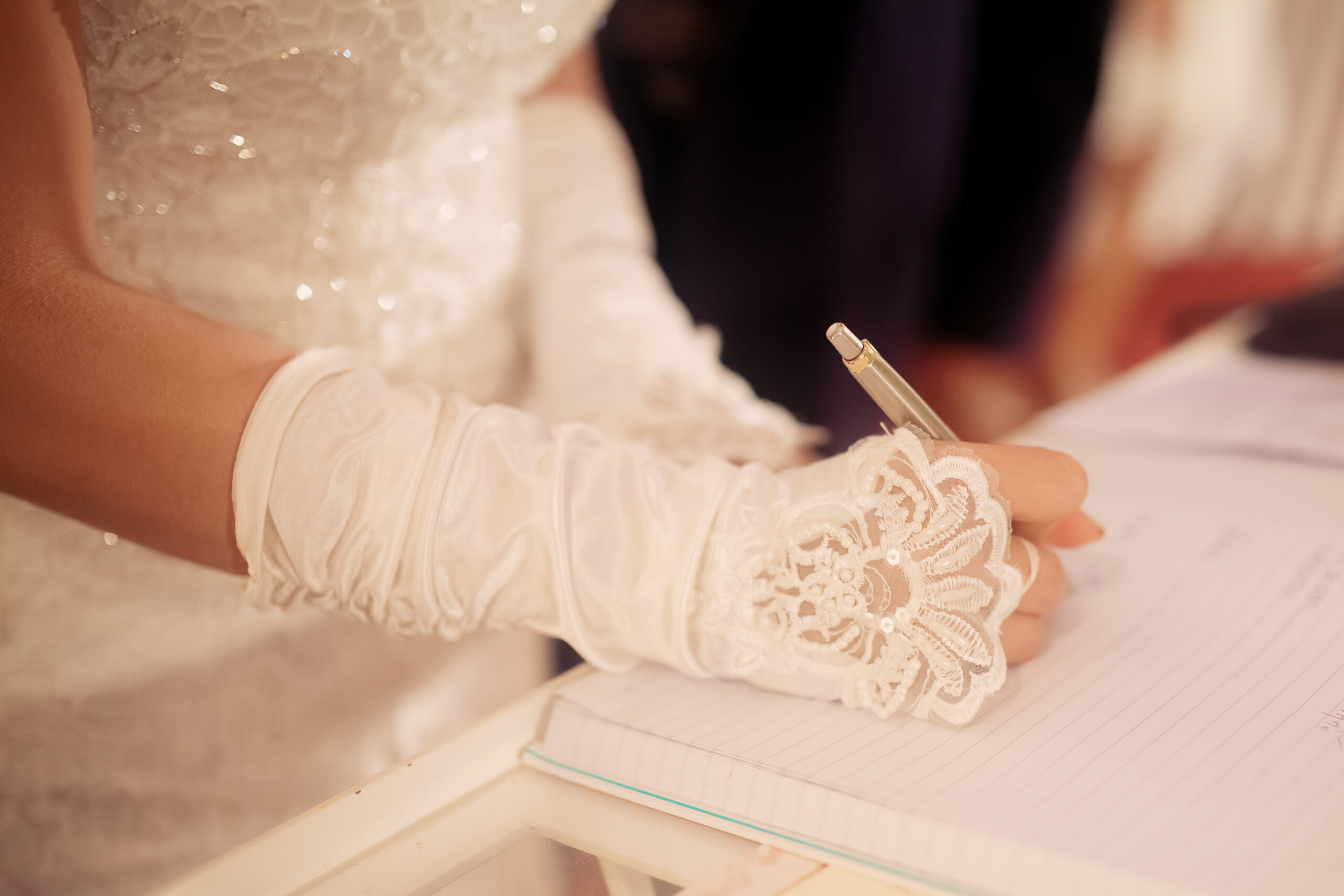 Bride hand with a pen signing wedding license