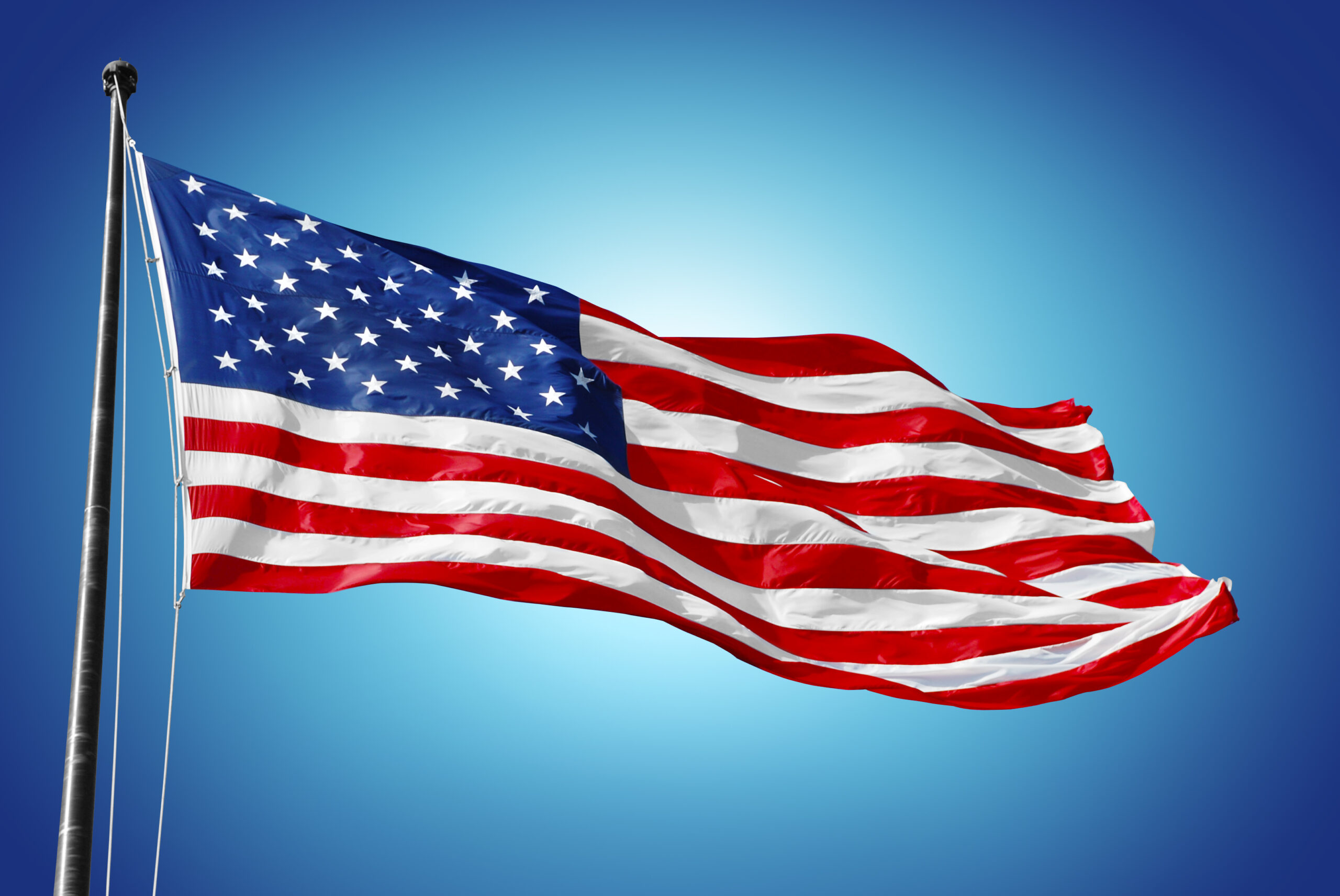 American flag waving against blue sky
