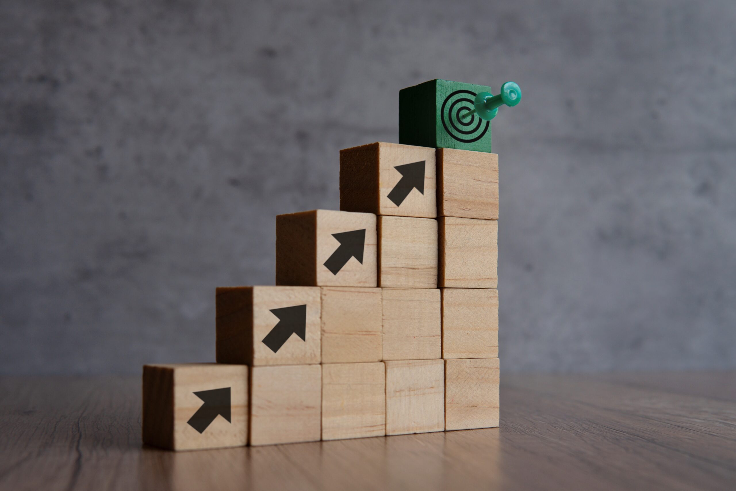 Wooden blocks with arrow and target board. Copy space for text. Business goals, objective and mission concept.