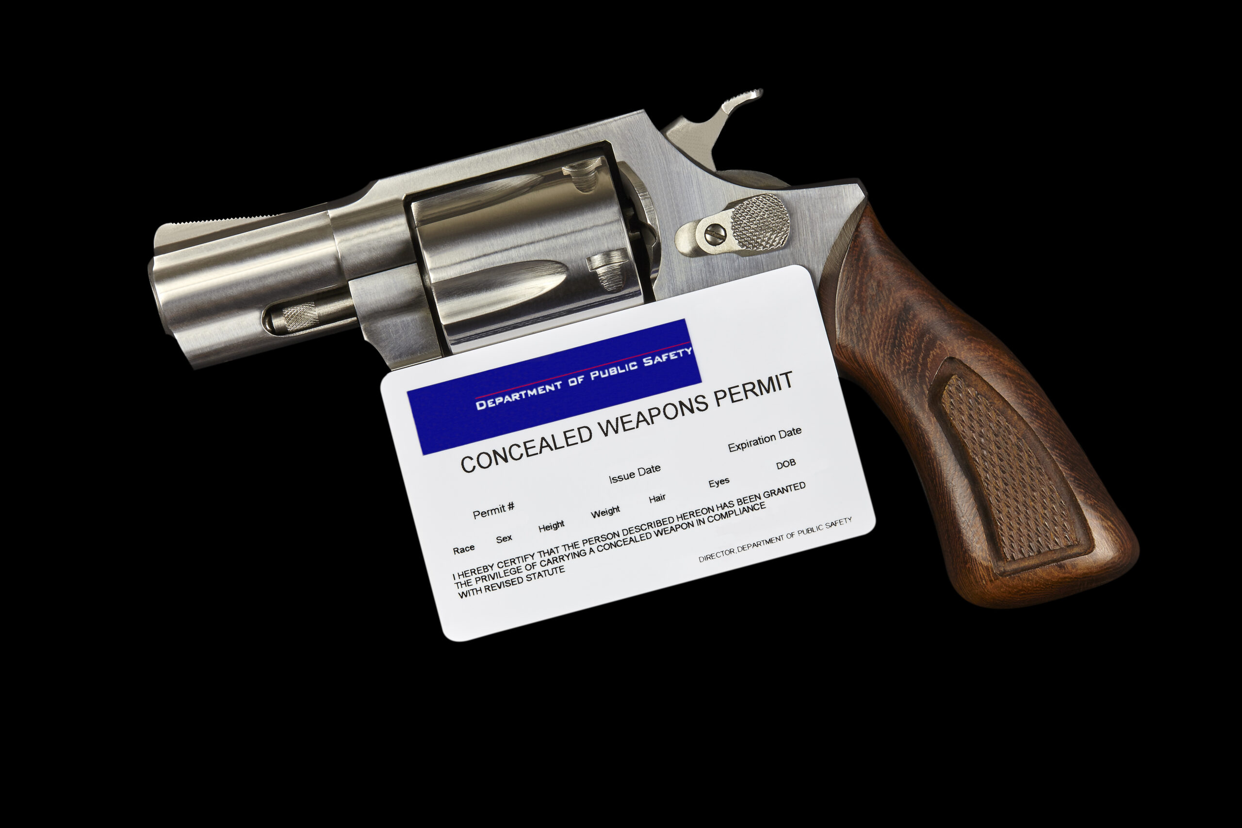 Revolver with Concealed Weapons Gun Permit Isolated on Black