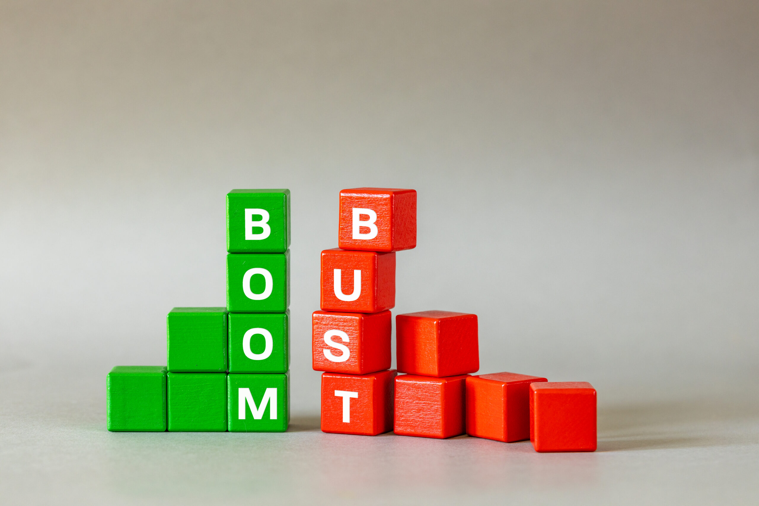 Boom and bust chart. Conceptual words, Business idea, Financial market, stock market trading, market speculation, profit and loss, Bull and bear market symbol on wooden blocks, gray background, copy space